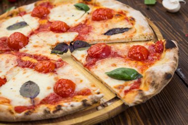 ahşap arka plan üzerinde rustik İtalyan pizza Margarita mozzarella peyniri, domates ve fesleğen yaprakları