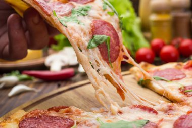 Mozzarella peyniri, salam ve roka ahşap zemin üzerine biberli pizza