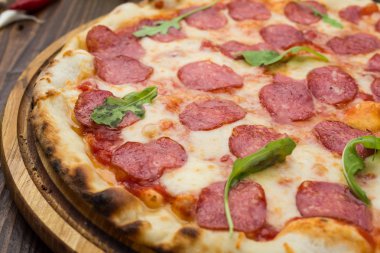 Mozzarella peyniri, salam ve roka ahşap zemin üzerine biberli pizza