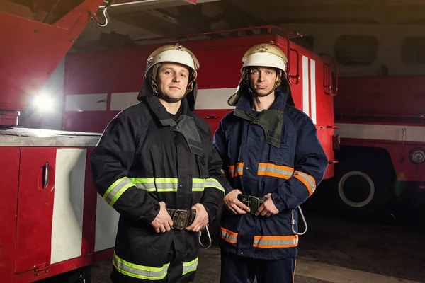 İtfaiyeci (itfaiye) eylem daimi bir firetruck yakınındaki. Acil durum Emanet. Koruma, tehlikeden kurtarmak.