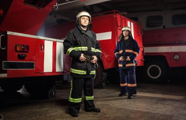 İtfaiyeci (itfaiye) eylem daimi bir firetruck yakınındaki. Acil durum Emanet. Koruma, tehlikeden kurtarmak.