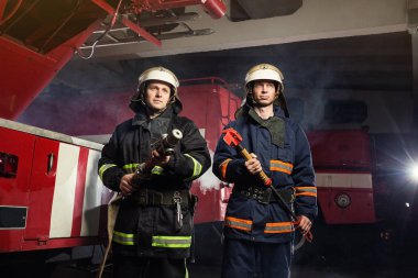 İtfaiyeci (itfaiye) eylem daimi bir firetruck yakınındaki. Acil durum Emanet. Koruma, tehlikeden kurtarmak.