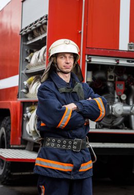 İtfaiyeci (itfaiye) eylem daimi bir firetruck yakınındaki. Acil durum Emanet. Koruma, tehlikeden kurtarmak.