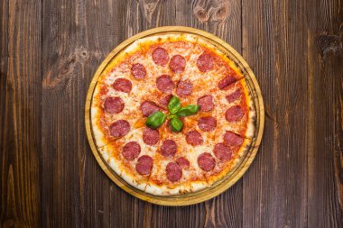 Mozzarella peyniri, salam ve roka ahşap zemin üzerine biberli pizza