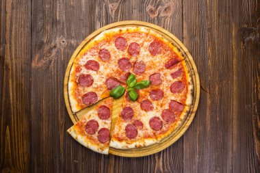 Mozzarella peyniri, salam ve roka ahşap zemin üzerine biberli pizza