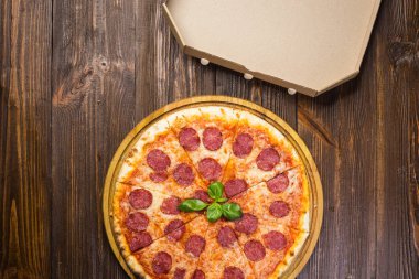 Mozzarella peyniri, salam ve roka kutusu ahşap zemin üzerine biberli pizza