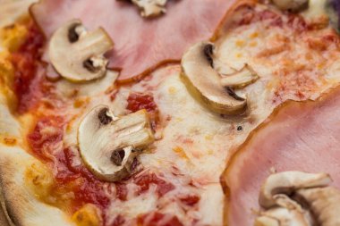 Jambon ve mantar ahşap arka plan üzerinde lezzetli İtalyan pizza