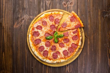 Mozzarella peyniri, salam ve roka ahşap zemin üzerine biberli pizza