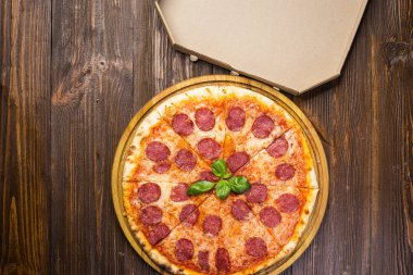 Mozzarella peyniri, salam ve roka kutusu ahşap zemin üzerine biberli pizza