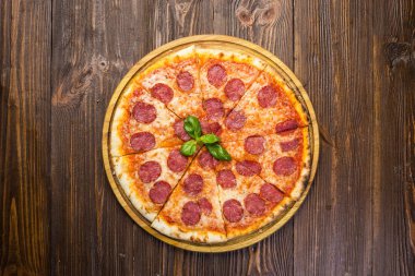 Mozzarella peyniri, salam ve roka ahşap zemin üzerine biberli pizza