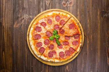 Mozzarella peyniri, salam ve roka ahşap zemin üzerine biberli pizza