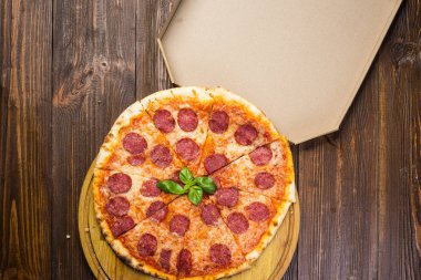 Mozzarella peyniri, salam ve roka kutusu ahşap zemin üzerine biberli pizza