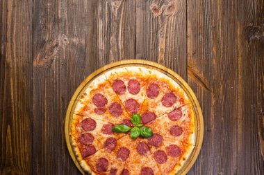 Mozzarella peyniri, salam ve roka ahşap zemin üzerine biberli pizza