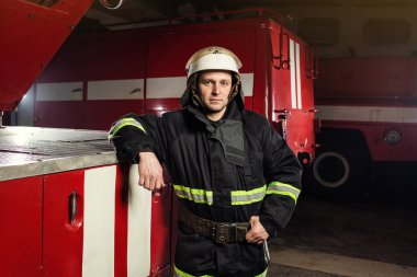 İtfaiyeci (itfaiye) eylem daimi bir firetruck yakınındaki. Acil durum Emanet. Koruma, tehlikeden kurtarmak.