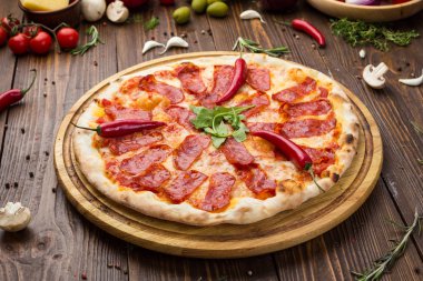Mozzarella peyniri, salam ve roka ahşap zemin üzerine biberli pizza