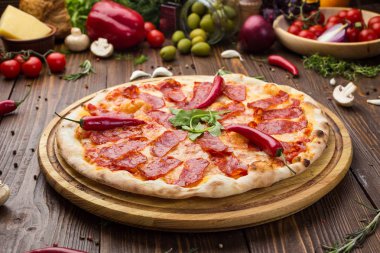 Mozzarella peyniri, salam ve roka ahşap zemin üzerine biberli pizza