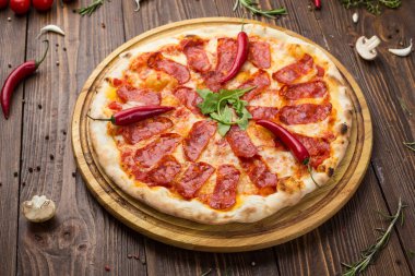 Mozzarella peyniri, salam ve roka ahşap zemin üzerine biberli pizza