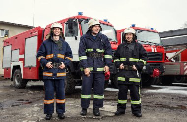 İtfaiyeci (itfaiye) eylem daimi bir firetruck yakınındaki. Acil durum Emanet. Koruma, tehlikeden kurtarmak.