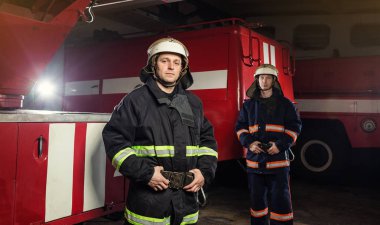 İtfaiyeci (itfaiye) eylem daimi bir firetruck yakınındaki. Acil durum Emanet. Koruma, tehlikeden kurtarmak.