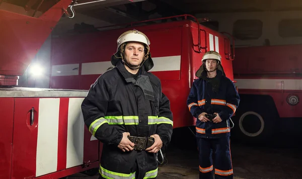 İtfaiyeci (itfaiye) eylem daimi bir firetruck yakınındaki. Acil durum Emanet. Koruma, tehlikeden kurtarmak.