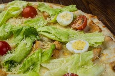 Pizza Sezar tavuk ve ahşap arka plan domates