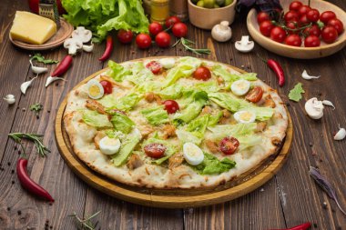 Pizza Sezar tavuk ve ahşap arka plan domates