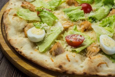 Pizza Sezar tavuk ve ahşap arka plan domates