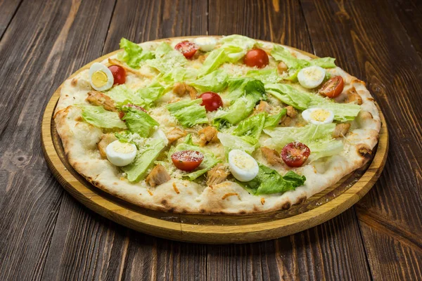 Pizza Sezar tavuk ve ahşap arka plan domates