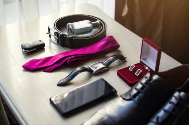 Bir iş adamının farklı aksesuarları ahşap bir arka planda yatar.