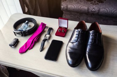 Bir iş adamının farklı aksesuarları ahşap bir arka planda yatar.