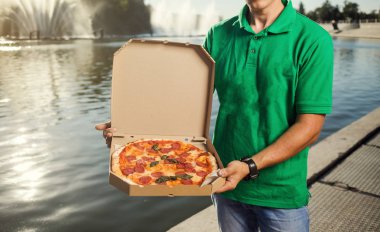 Yakışıklı delikanlı pizza müşteriye teslim