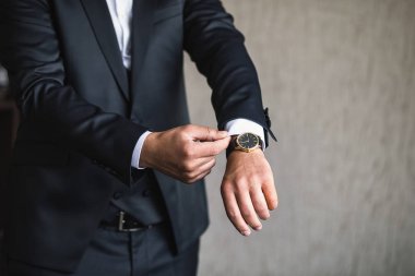 İş adamı ceket giyiyor, erkek eli kapalı, damat düğün töreninden önce hazırlanıyor.
