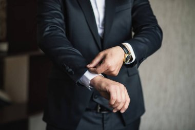 İş adamı ceket giyiyor, erkek eli kapalı, damat düğün töreninden önce hazırlanıyor.