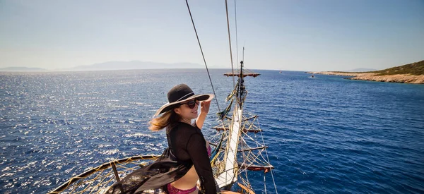 Beautiful girl in hat relaxing on the boat and looking at the island. Travelling vocation tour in Turkey