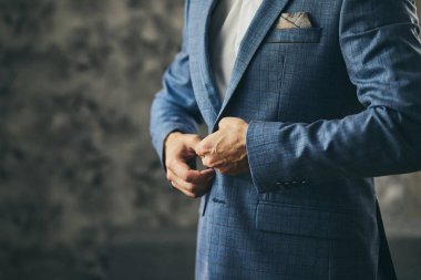 İş adamı ceket giyiyor, erkek eli kapalı, damat düğün töreninden önce hazırlanıyor.