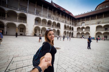 Genç ve mutlu kadın turist Wawel Kalesi eski Avrupa City Krakow, Polonya üzerinde yürüme. Fotoğraf beni takip edin. Avrupa'da seyahat