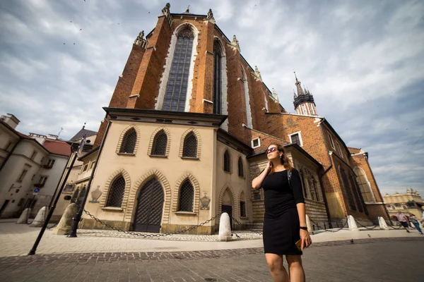 年轻而快乐的女游客走在欧洲老城克拉科夫的市场广场上 欧洲各地的旅行 — 图库照片