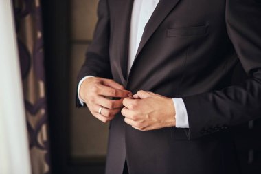 İşadamı takıyor bir ceket, Erkek eller closeup, damat düğün töreni önce sabah hazırlanıyor. Erkek moda