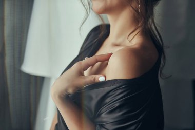 Camın yanında duran bornozuna kemer takan kız, düğün töreninden önce hazırlanan kadın.