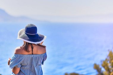 Bodrum, Türkiye'de güneşli gün, mavi gökyüzü ile deniz manzaralı zevk plaj şapkalı güzel bir kadın. Tatil açık havada deniz manzarası yaz seyahat kavramı