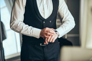 İş adamı kol saatini kontrol ediyor, saati eline alıyor, damat düğün töreninden önce hazırlanıyor. Erkekler Moda