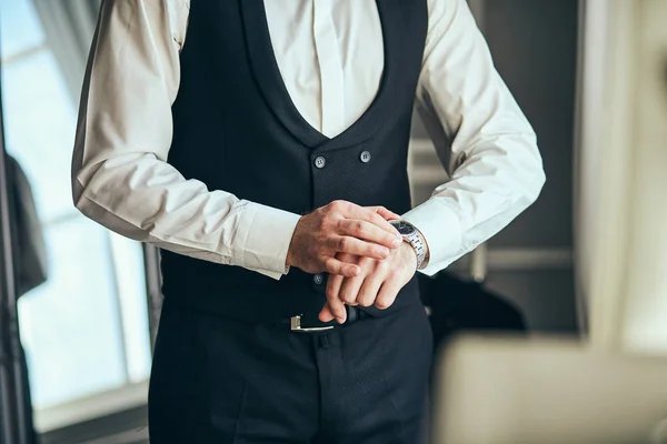 実業家が腕時計の時刻を調べてる男が時計を手にして結婚式の前の朝に新郎が準備をしてる 男性ファッション — ストック写真