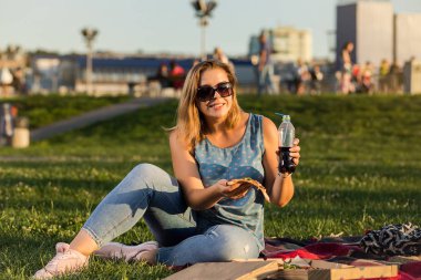 Sıcak pizza kutusunda, koltukta park açık tutan mutlu genç kadın