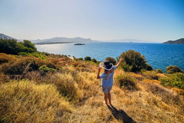 Bodrum, Türkiye'de güneşli gün, mavi gökyüzü ile deniz manzaralı zevk plaj şapkalı güzel bir kadın. Tatil açık havada deniz manzarası yaz seyahat kavramı