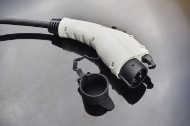 Elektrikli araba koyu arka plan üzerinde fiş şarj. Çevre dostu alternatif enerji kavramı.