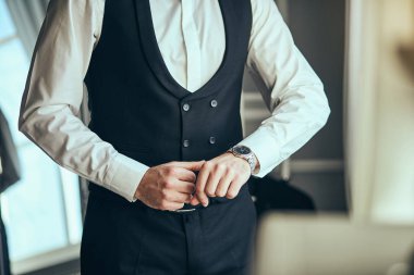 İş adamı kol saatini kontrol ediyor, saati eline alıyor, damat düğün töreninden önce hazırlanıyor. Erkekler Moda