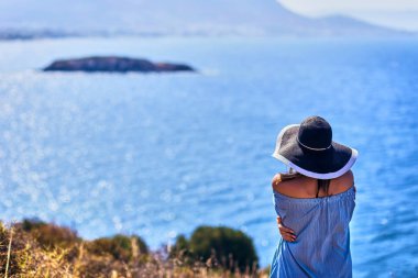 Bodrum, Türkiye'de güneşli gün, mavi gökyüzü ile deniz manzaralı zevk plaj şapkalı güzel bir kadın. Tatil açık havada deniz manzarası yaz seyahat kavramı