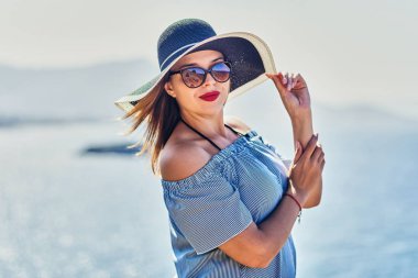 Bodrum, Türkiye'de güneşli gün, mavi gökyüzü ile deniz manzaralı zevk plaj şapkalı güzel bir kadın. Tatil açık havada deniz manzarası yaz seyahat kavramı