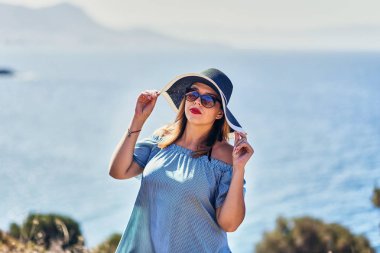 Bodrum, Türkiye'de güneşli gün, mavi gökyüzü ile deniz manzaralı zevk plaj şapkalı güzel bir kadın. Tatil açık havada deniz manzarası yaz seyahat kavramı