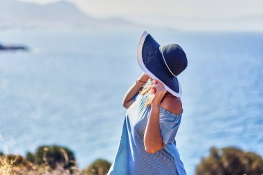 Bodrum, Türkiye'de güneşli gün, mavi gökyüzü ile deniz manzaralı zevk plaj şapkalı güzel bir kadın. Tatil açık havada deniz manzarası yaz seyahat kavramı